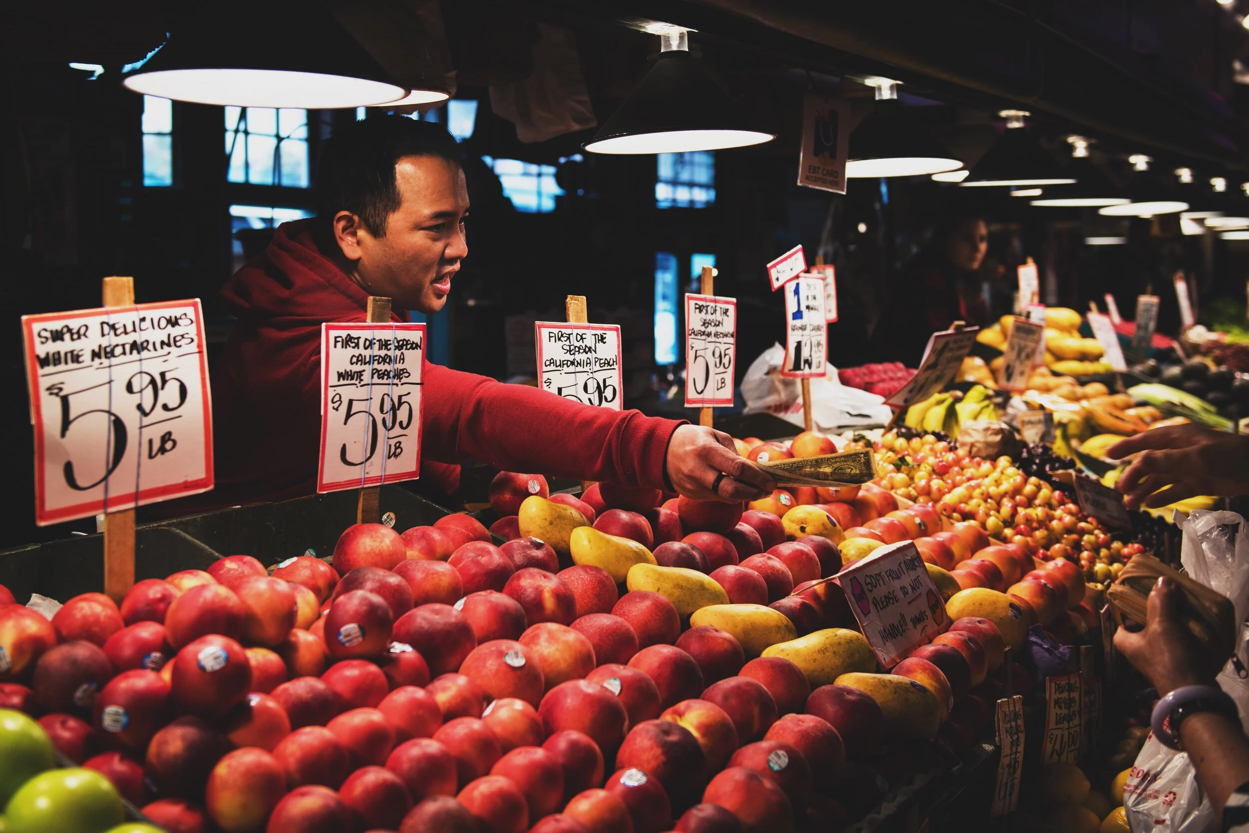 Picture of Asian male fruit vendor at Pike Place Market selling apples