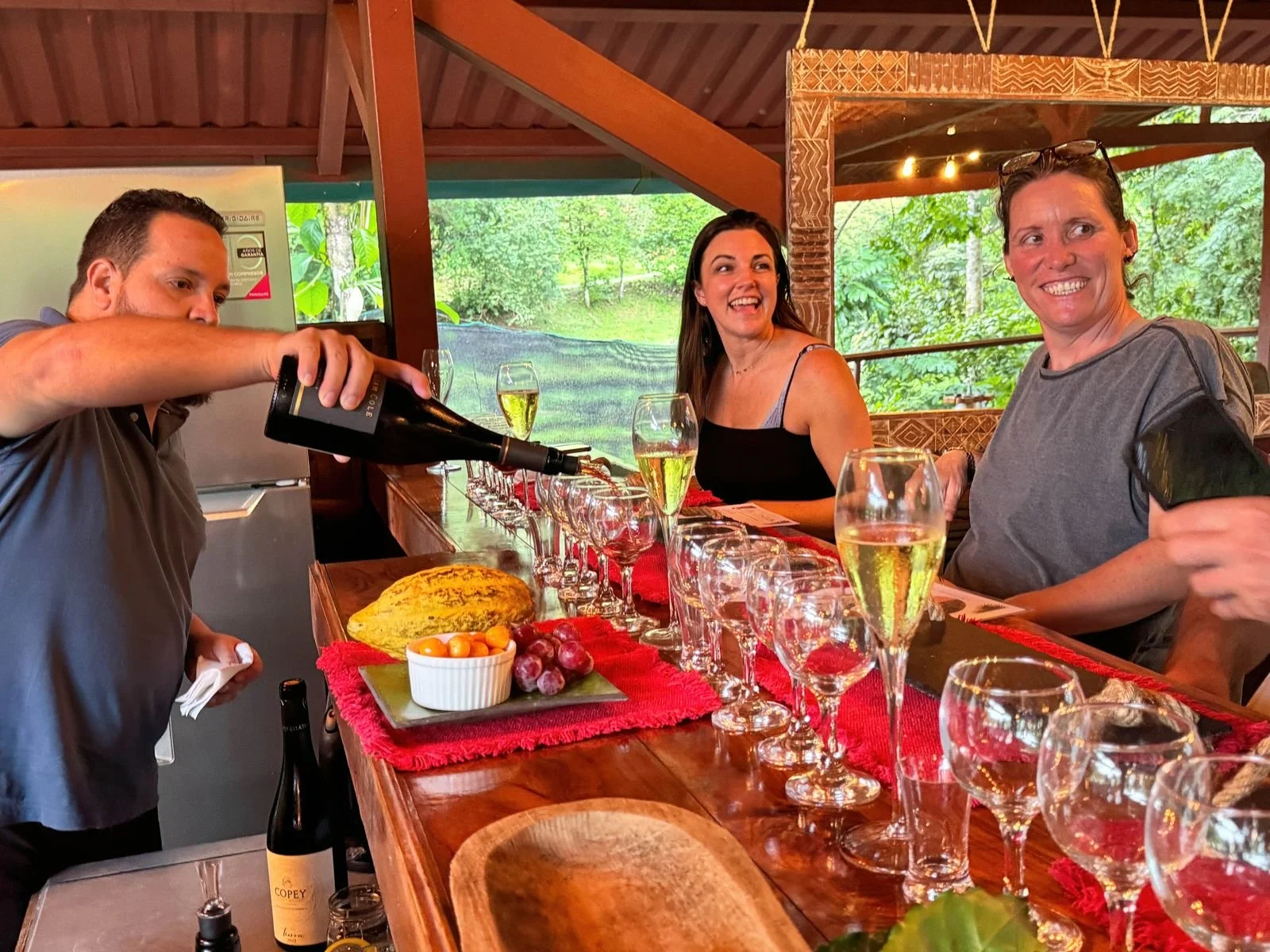 Guests enjoying wine and fresh flavors during the Tres Amigos tasting experience at Chorro Ecolodge near Manuel Antonio, Costa Rica.