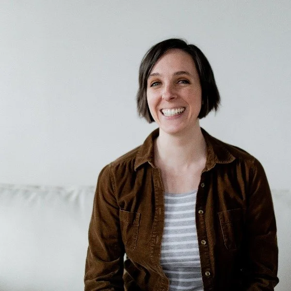 Jamie Richelle with short brown hair smiling, wearing a light blue denim shirt.  Rachel Jones Communications