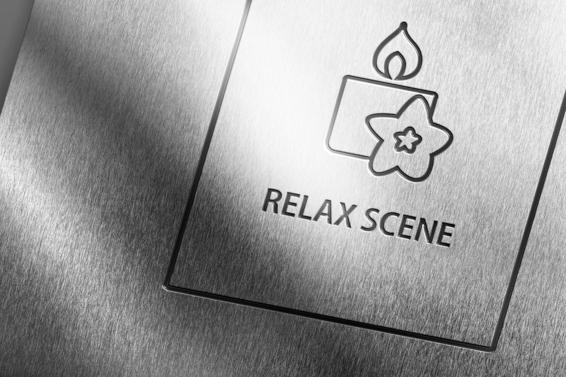 A metallic panel with an icon of a candle and flower, and the words 'RELAX SCENE' engraved.