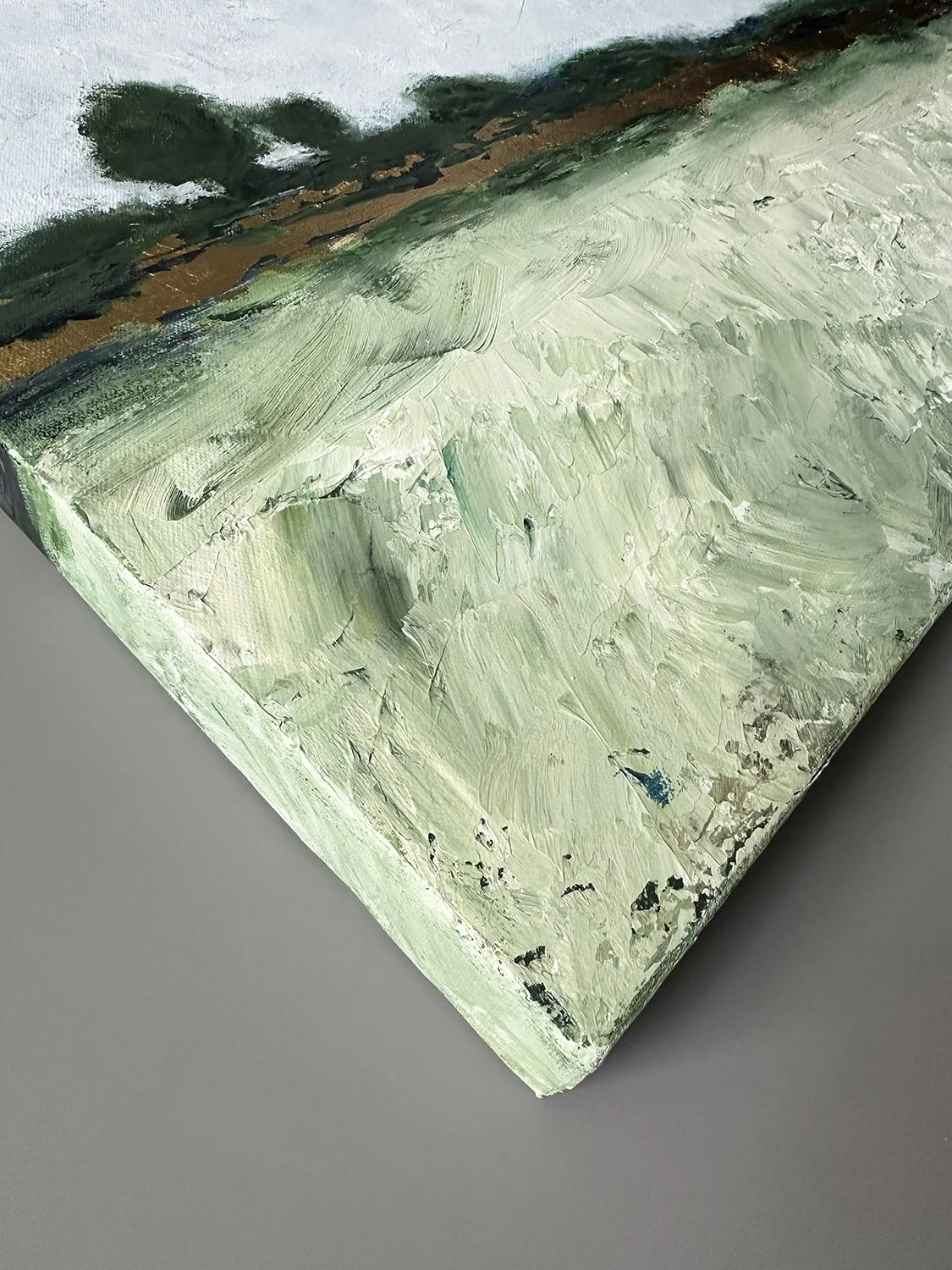 Corner detail of gallery-wrapped canvas meadow landscape painting.