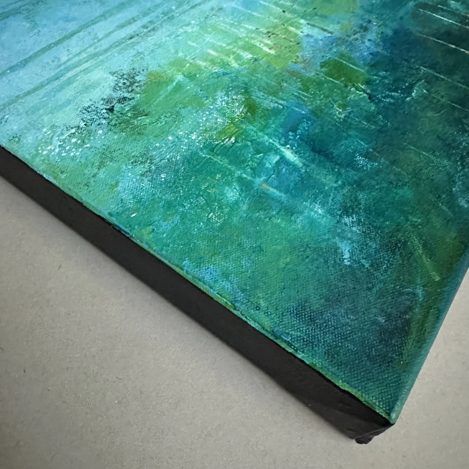 Corner detail of gallery-wrapped canvas abstract water painting.
