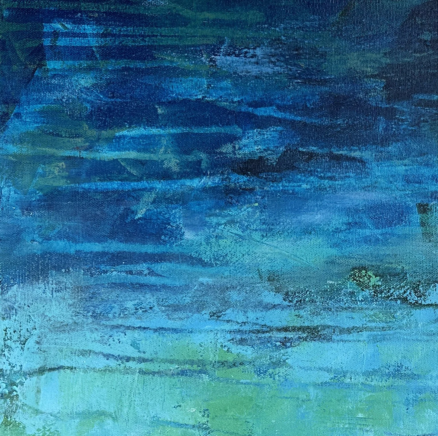 Close-up detail of the layering of vibrant colors in a blue abstract water painting.