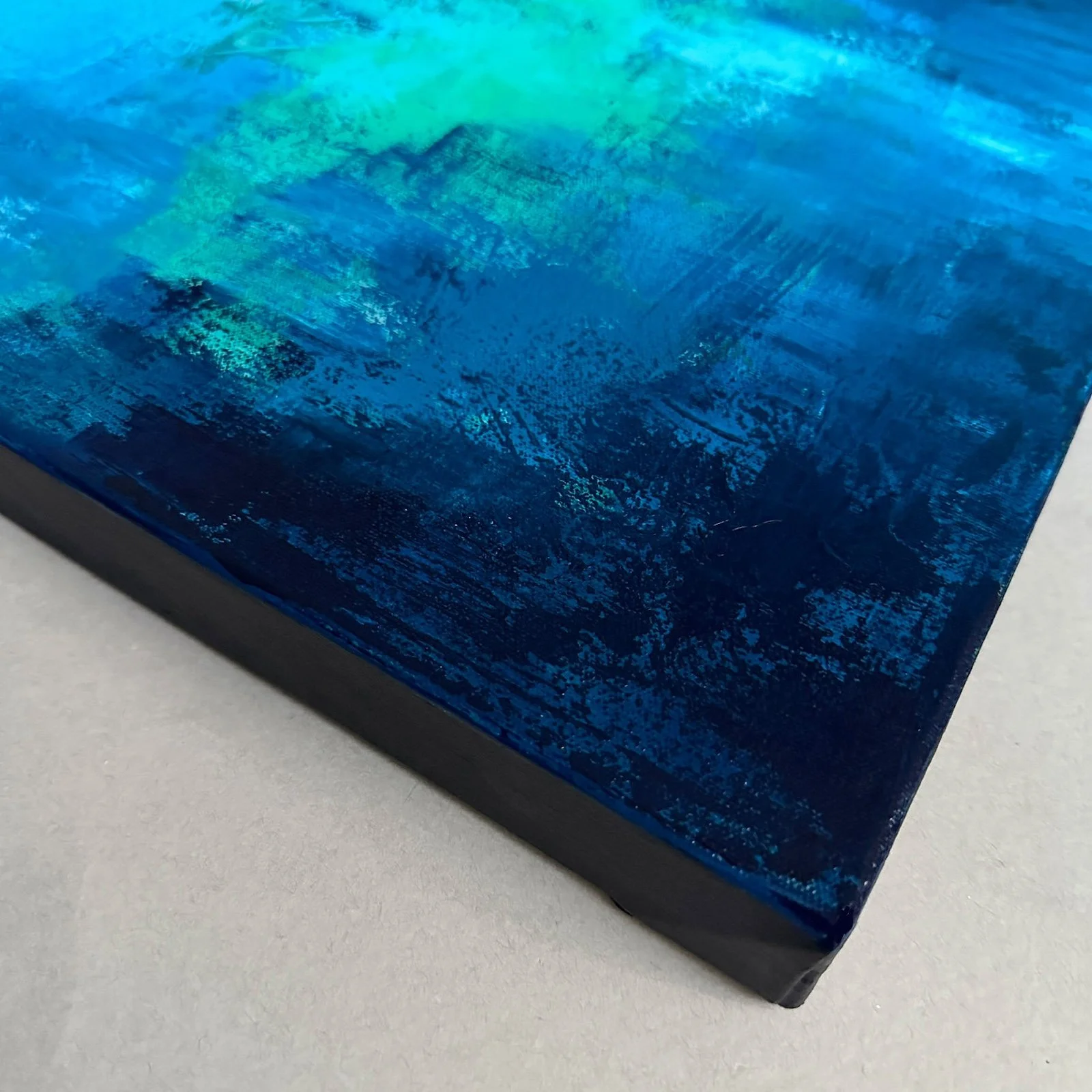 Corner detail of gallery-wrapped canvas abstract water painting.