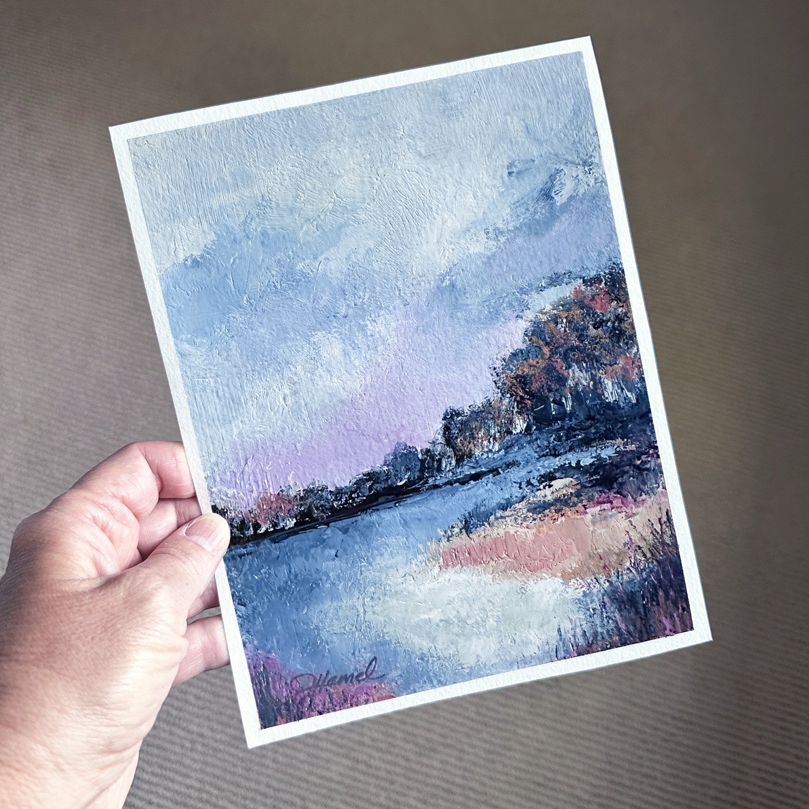 Hand holding deep blue water landscape scene