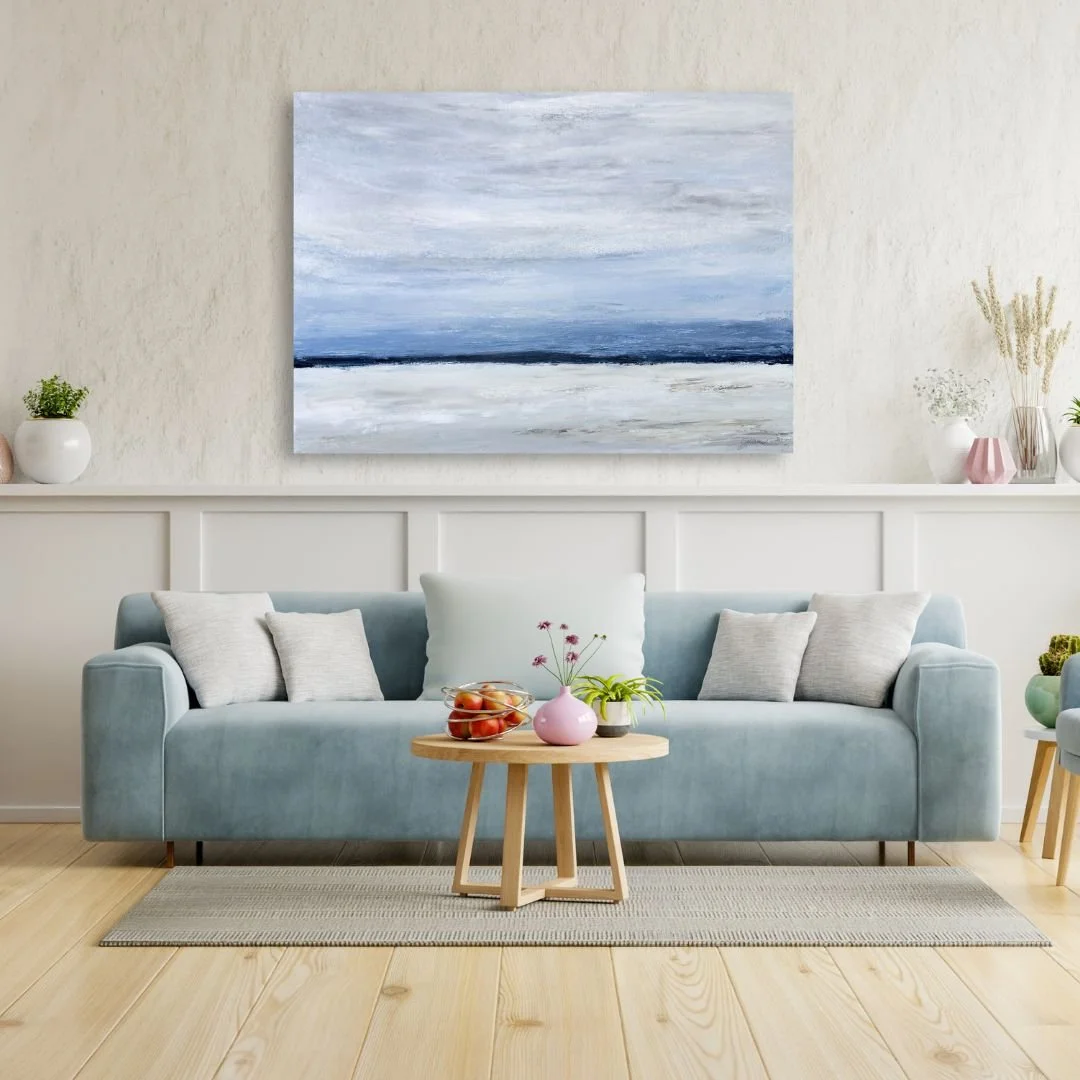 Large ocean acrylic landscape painting displayed on a wall above couch.