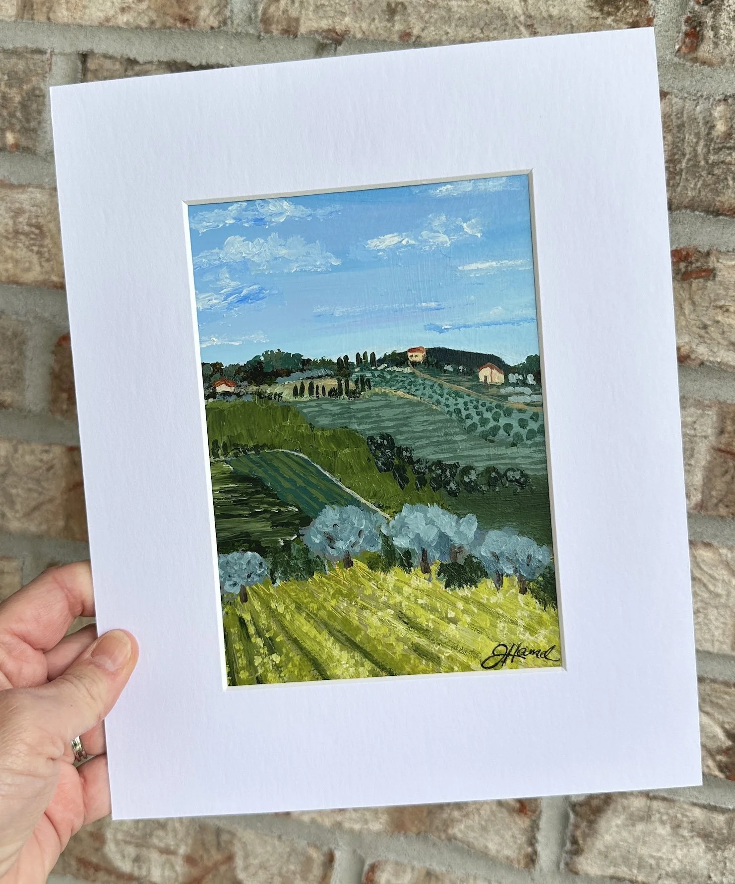 Small Tuscan landscape painting on paper displayed in a white mat.