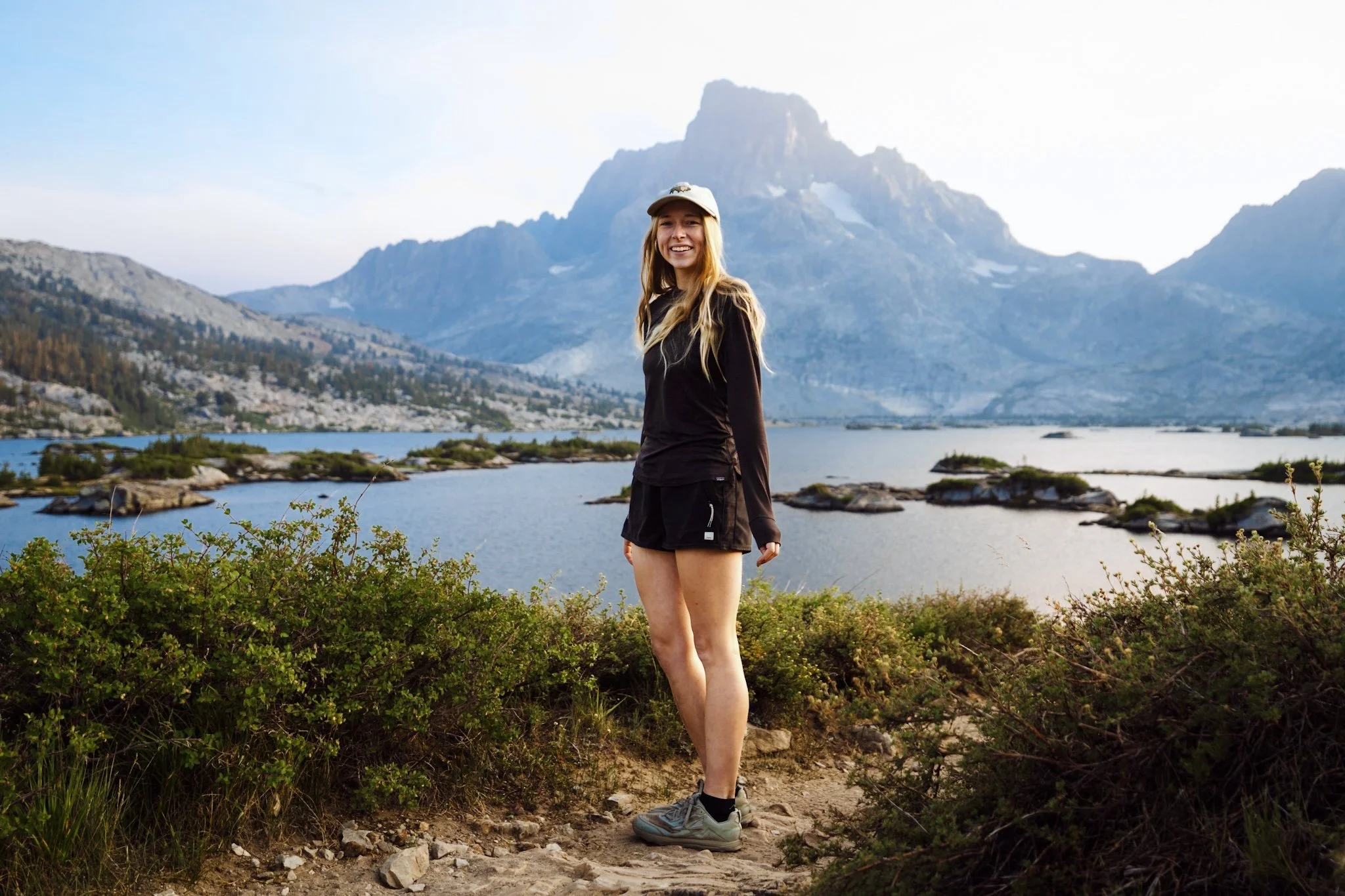 Women wearing various hiking shorts on mountain trail showing different fits for thick thighs