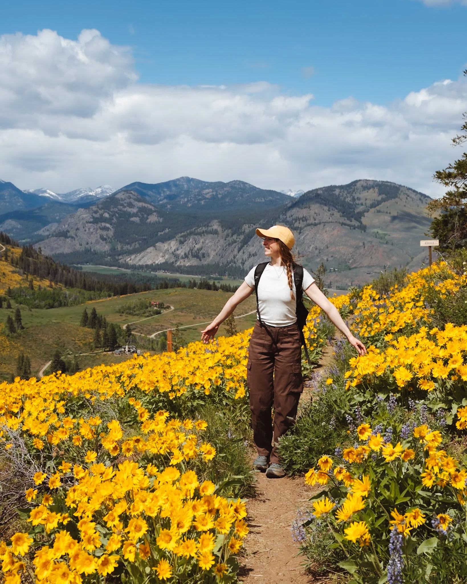 Wearing prana women's hiking pants hiking in Washington State on hiking trail with wildflowers