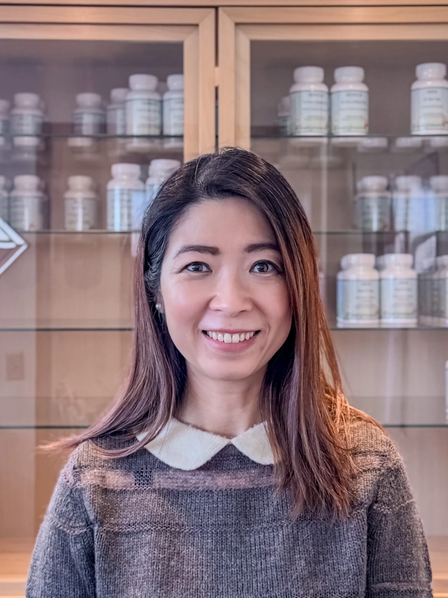 A mountain peak at sunset with a sky blending orange and yellow hues, snow-capped summit, and dark silhouette of surrounding mountains.
