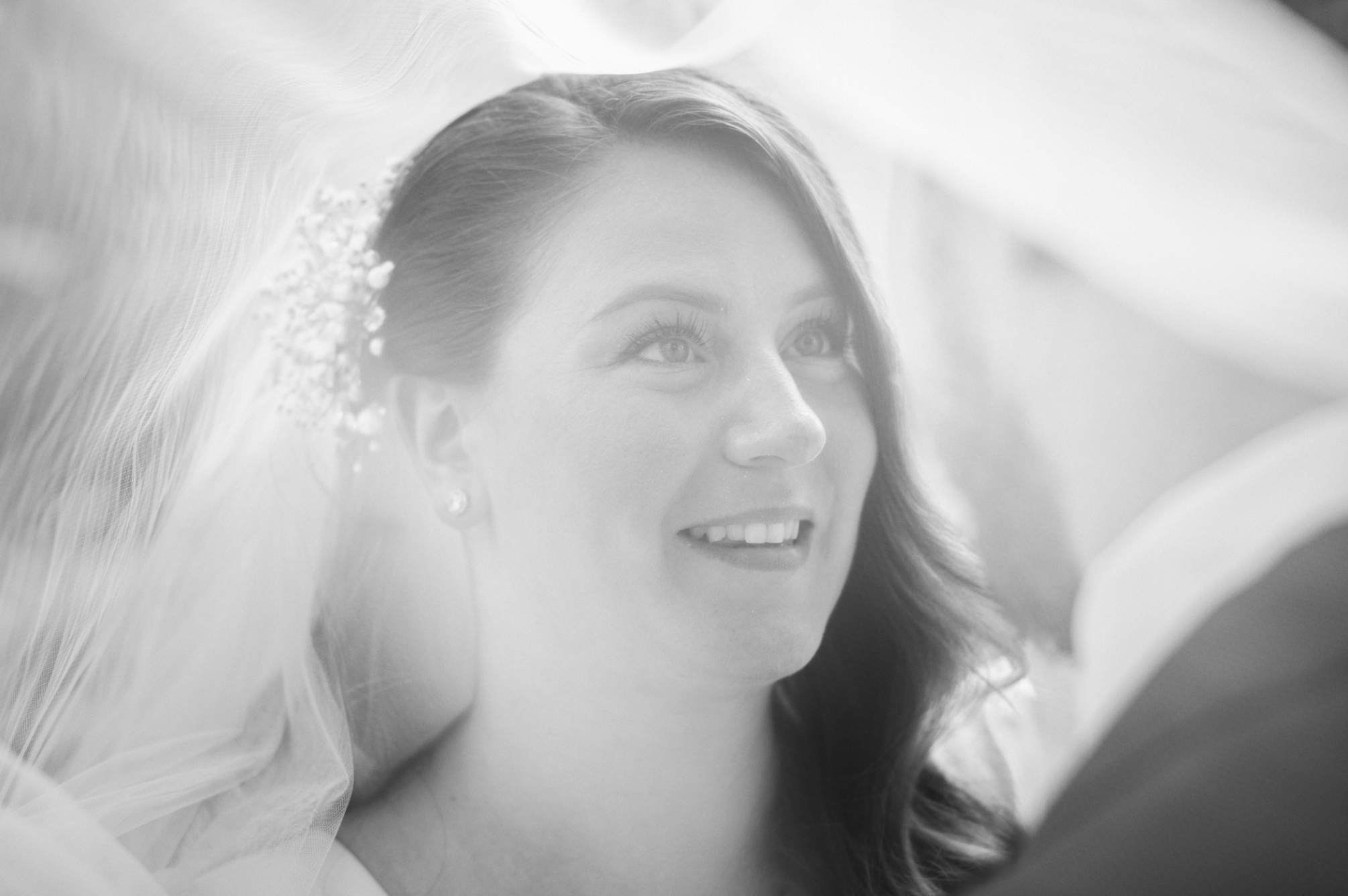 Svart-hvitt nærportrett av brud under et gjennomsiktig slør, et mykt og romantisk øyeblikk fra bryllupet på Rosanes i Færder.