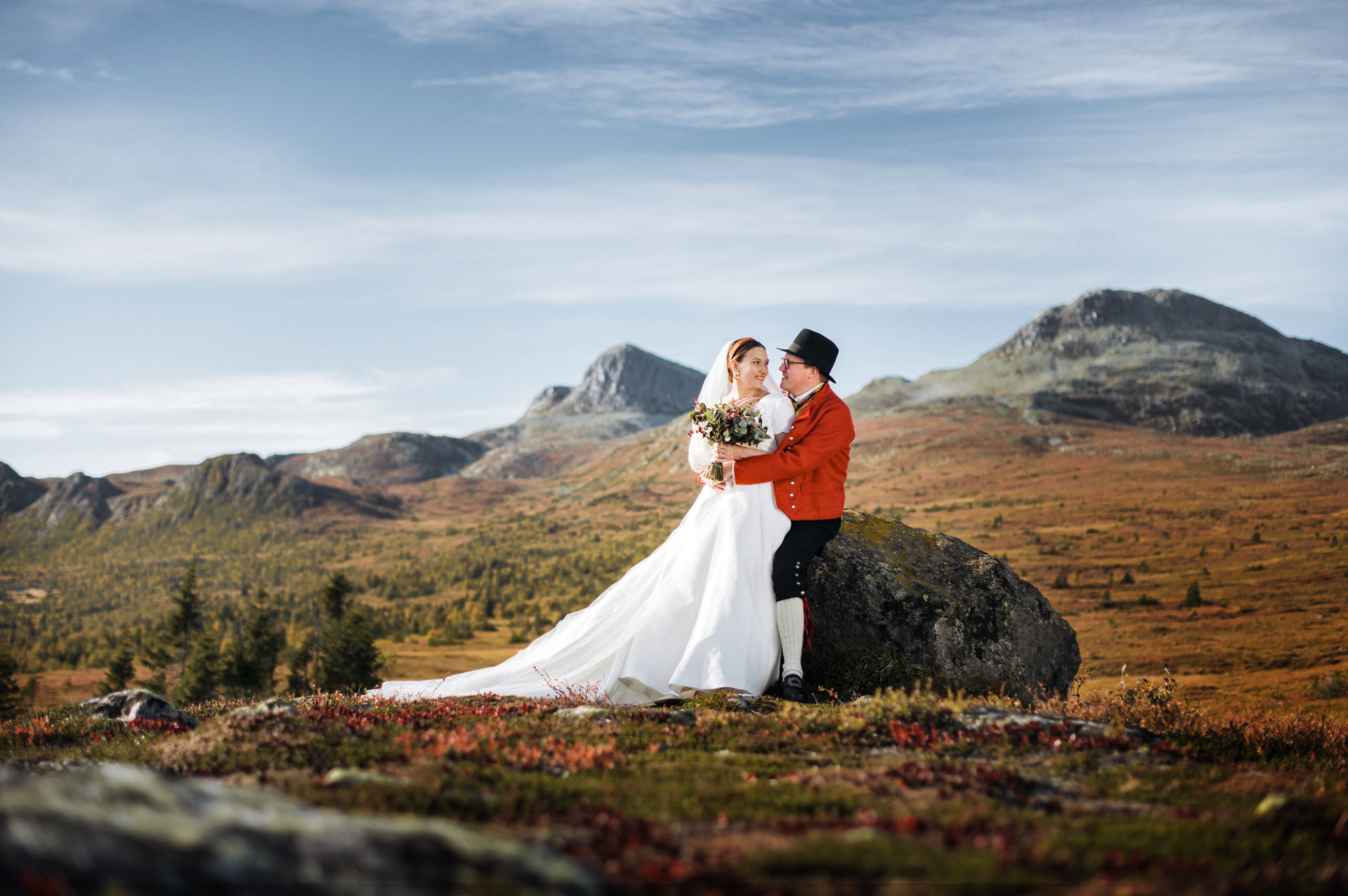 Brudepar poserer i norsk fjellandskap med vid utsikt, et dramatisk og stemningsfullt bryllupsportrett i naturen ved Tuddal.