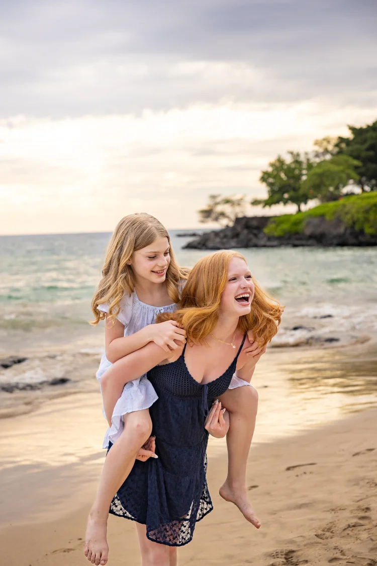 Family walking hand in hand on white sand beach at golden hour