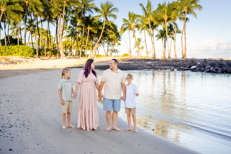 A family sitting together on the lawn with the ocean behind them