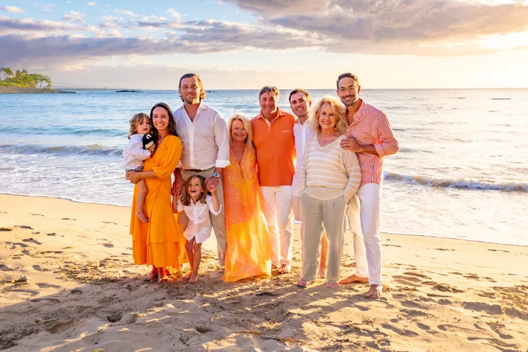 Three generations of one family together on the beach at sunset