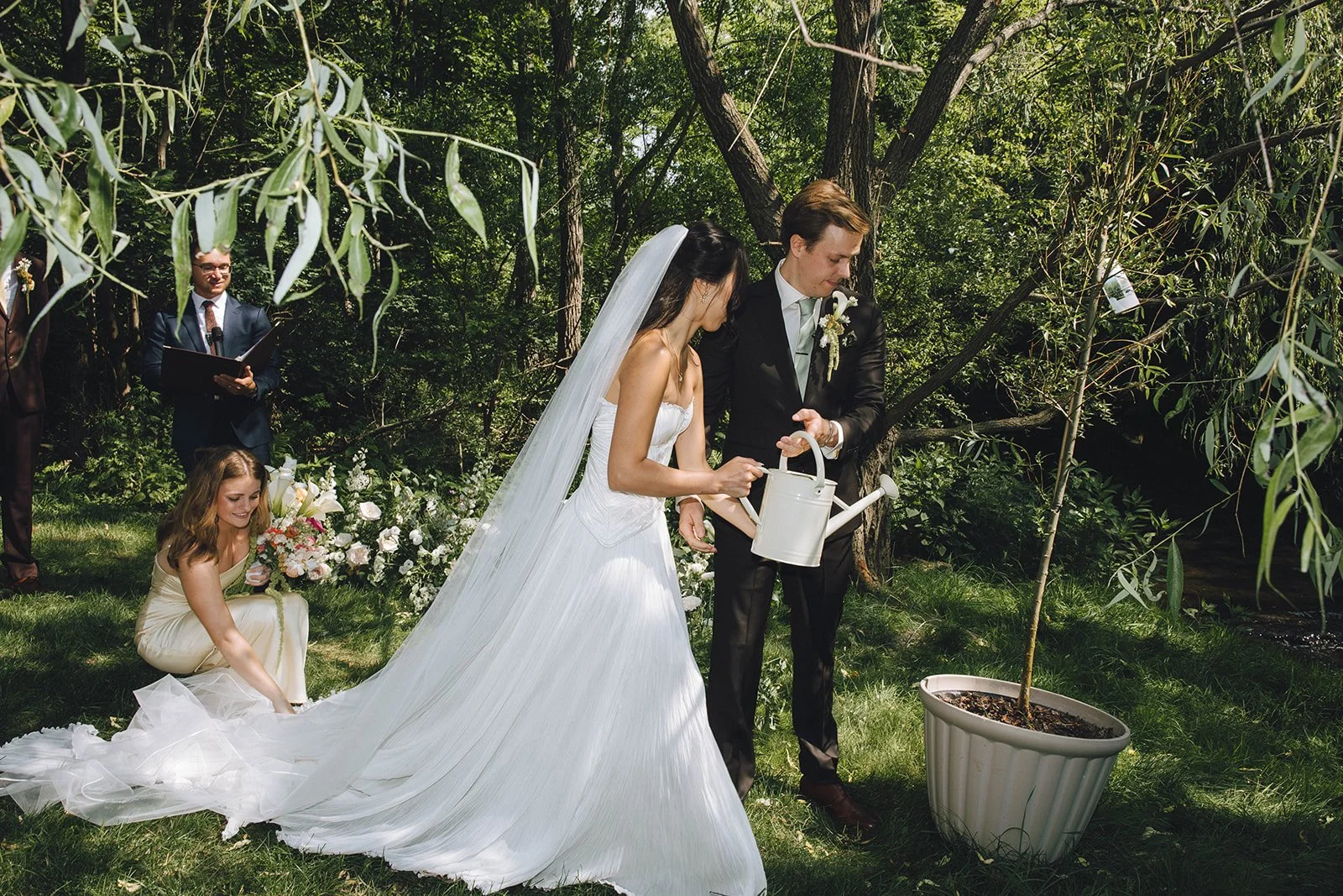 Kali and Zach exchanging vows beneath a willow tree at their backyard wedding in Upstate New York