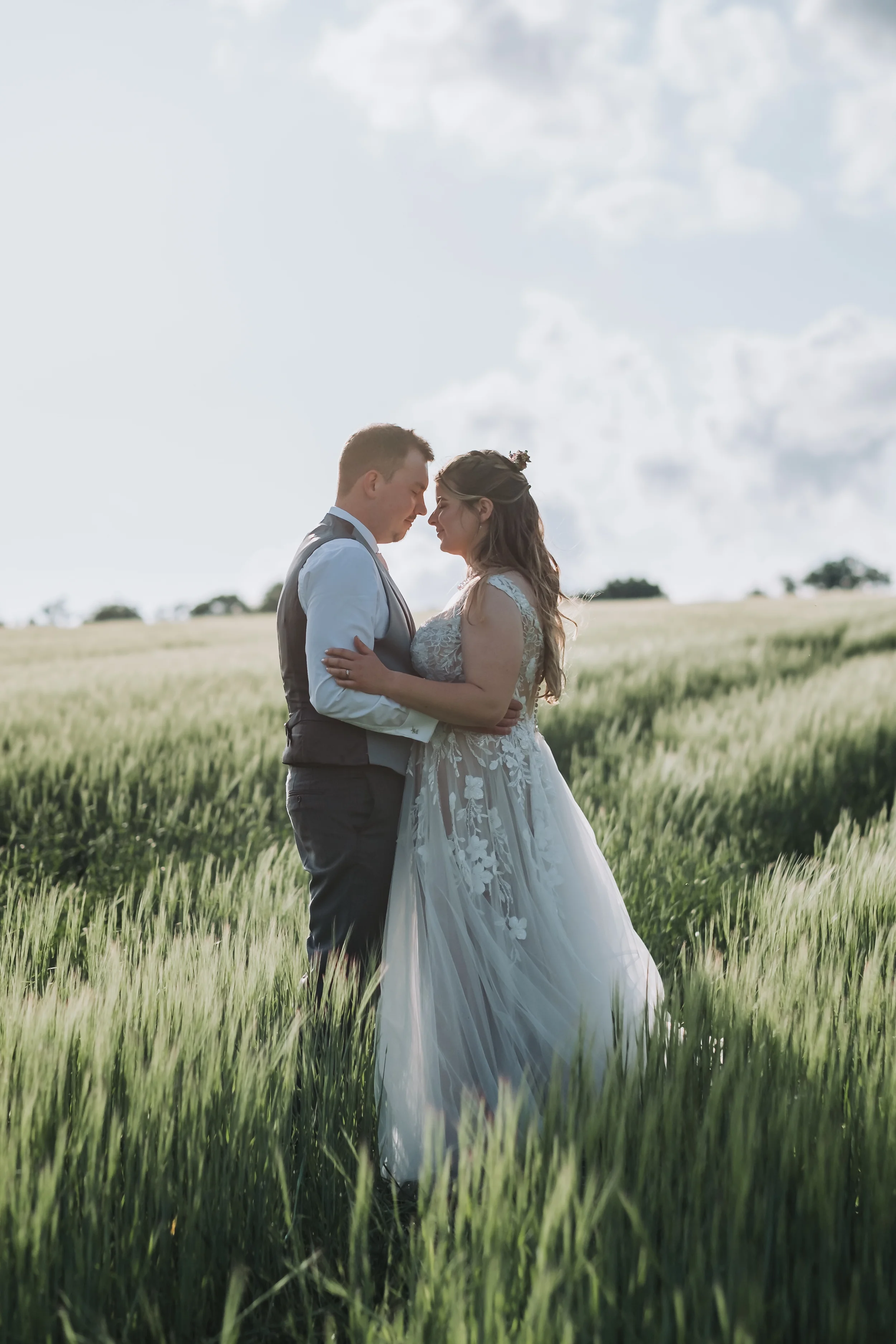 wedding photographer in bedfordshire, hertfordshire and cambridgeshire-bride and groom in a field for a photo on their wedding day