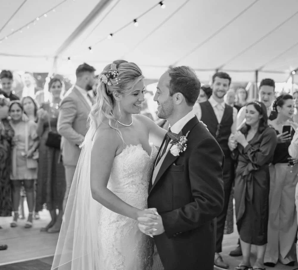 wedding photograph of the bride and groom dancing during their first dance in black and white