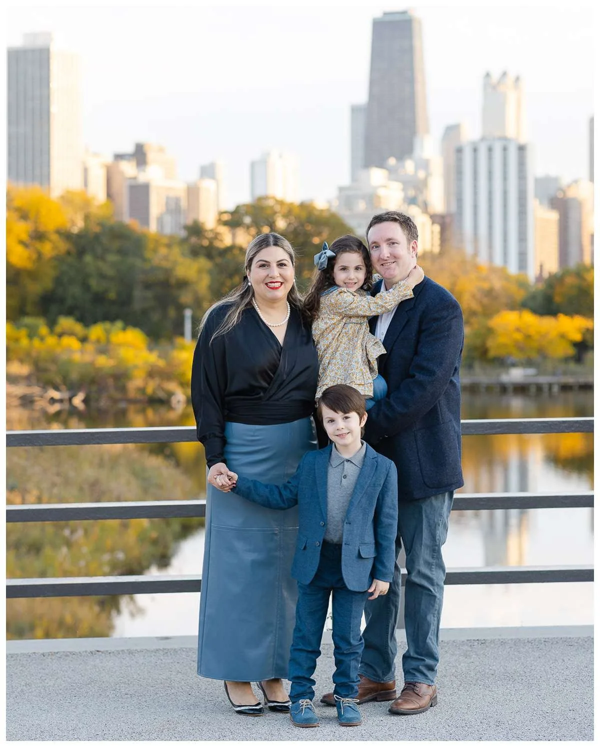 Parents picking up daughter and holding sun's hand at Lincoln Park Zoo Bridge in Chicago