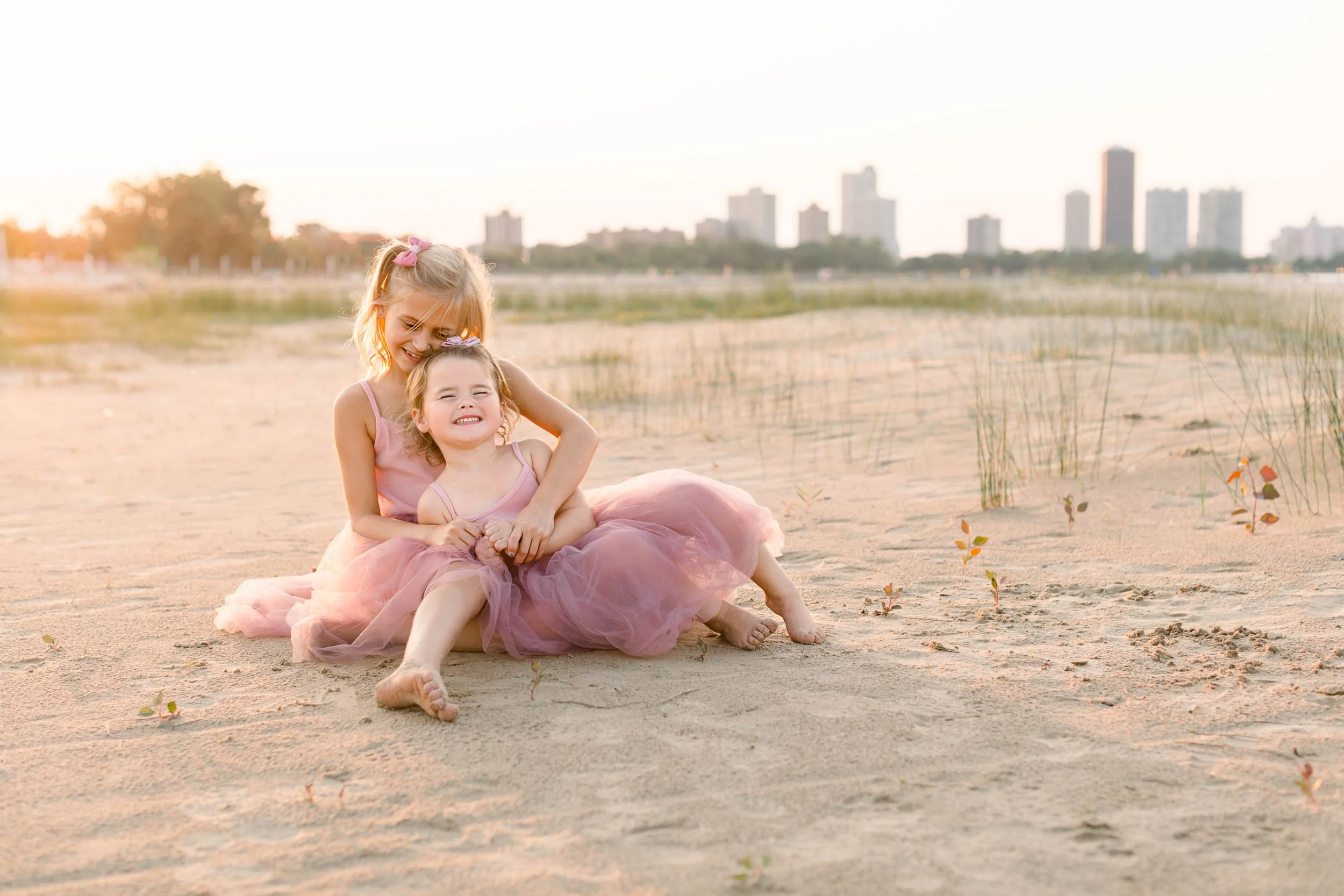 Sisters hugging during golden hour at the beach by Chicago Family Photographer