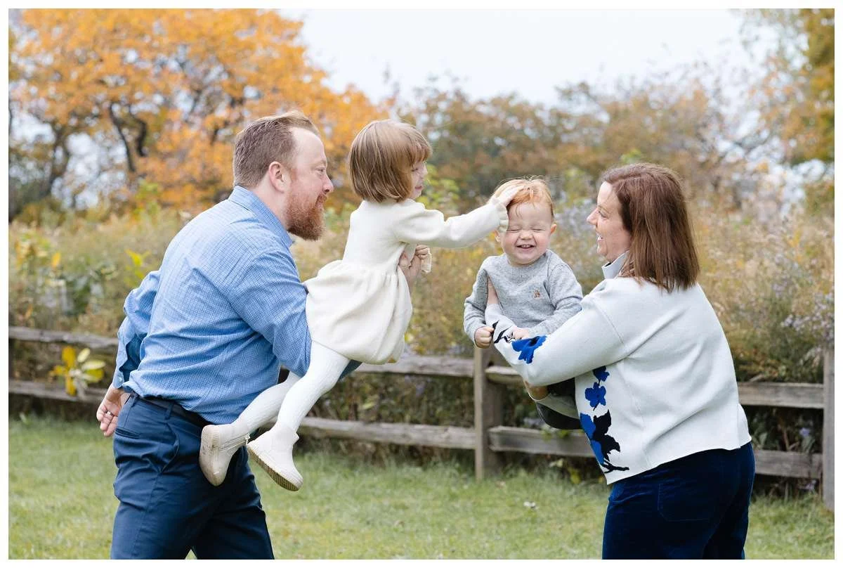 Each parent holding a kid and having them fly to meet in the middle with little girl touching brother's head