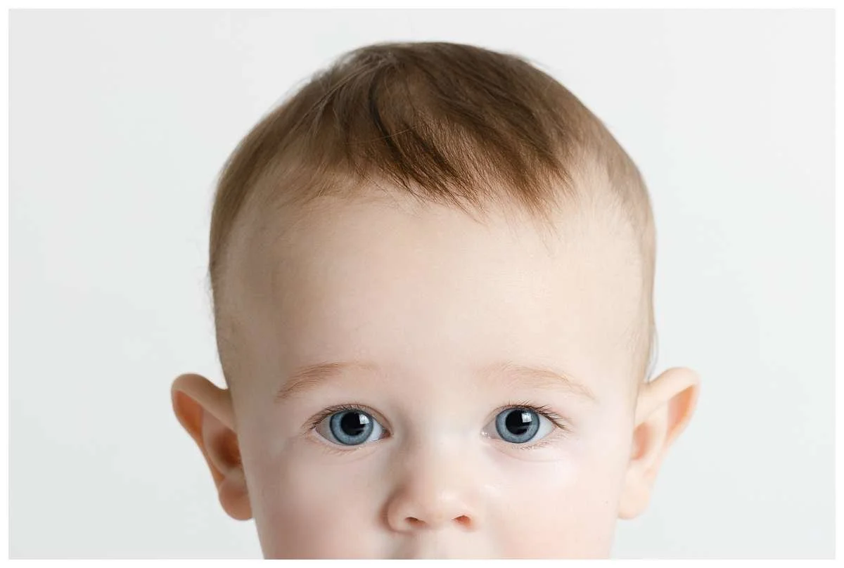Top portion of little boy's head with blue eyes starting straight to the camera
