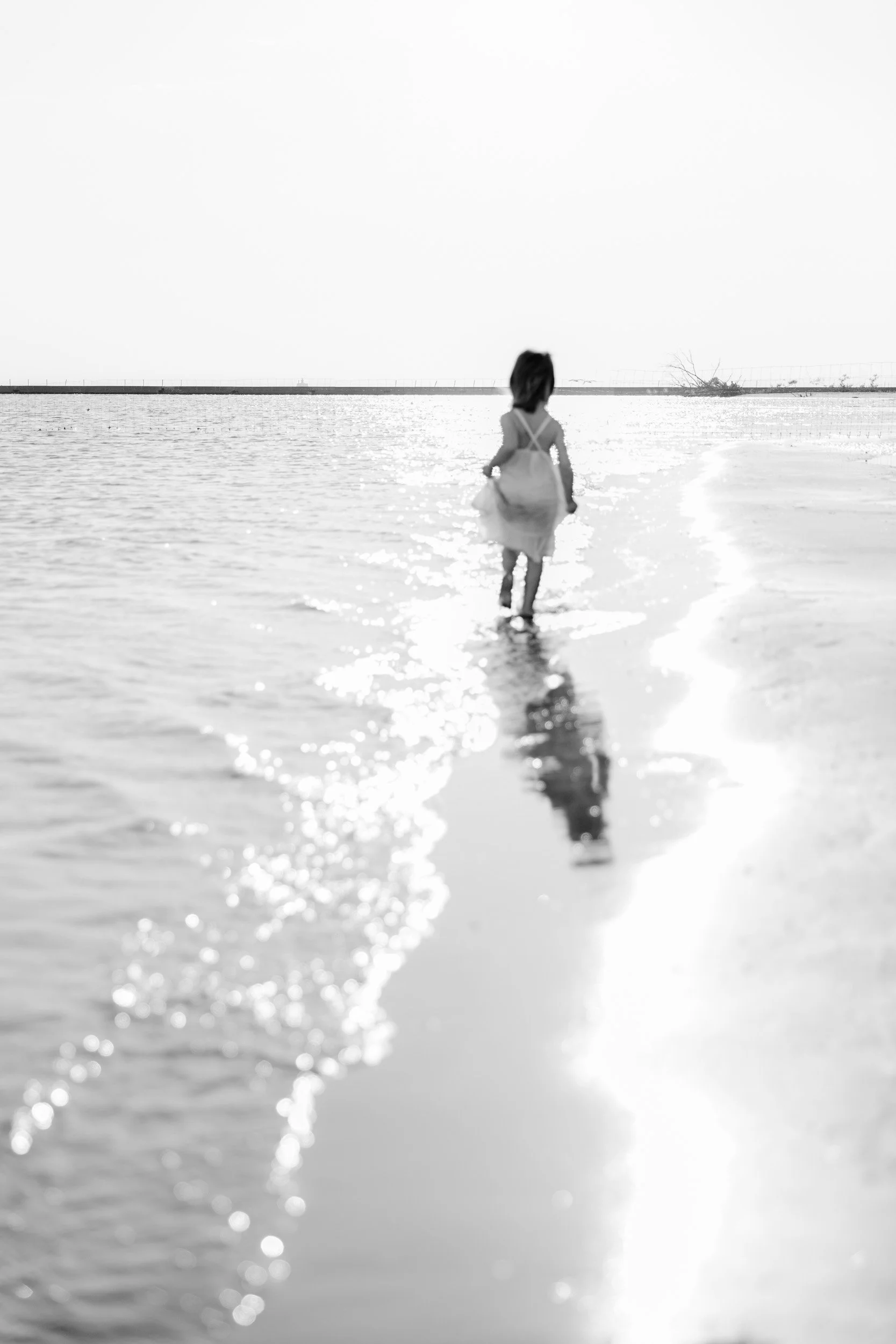 Girl running along the North Avenue Beach towards sunset by Chicago Photographer