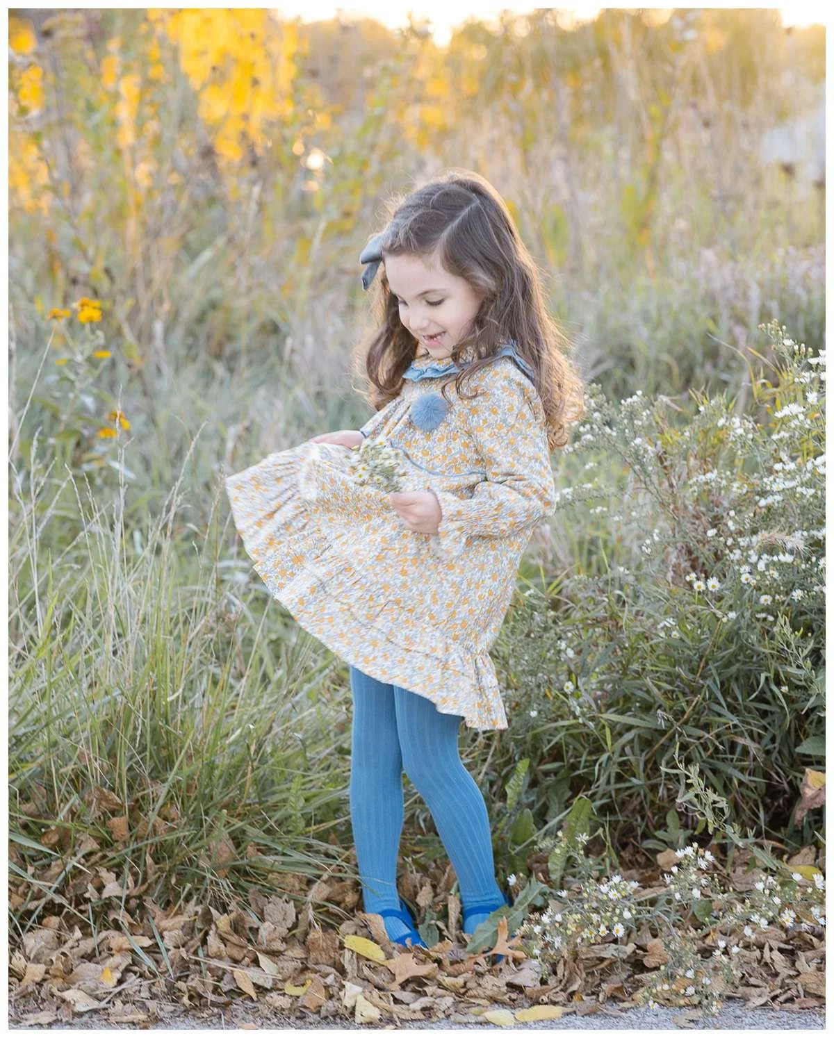 Young girl swinging her dress as she holds flowers on her hand