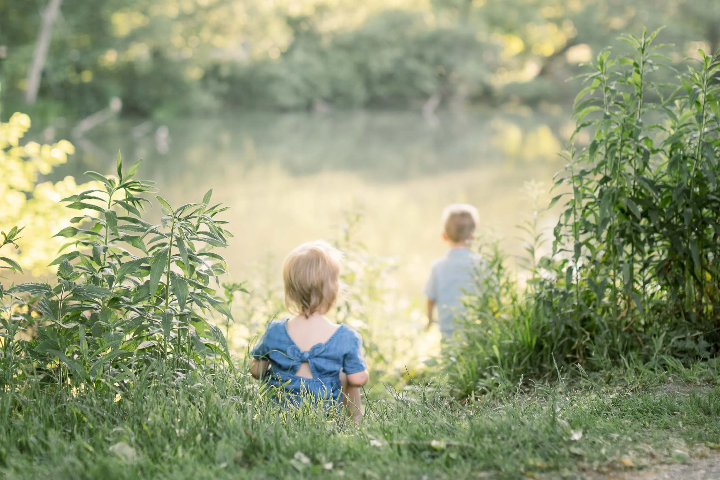Back of two siblings exploring the woods