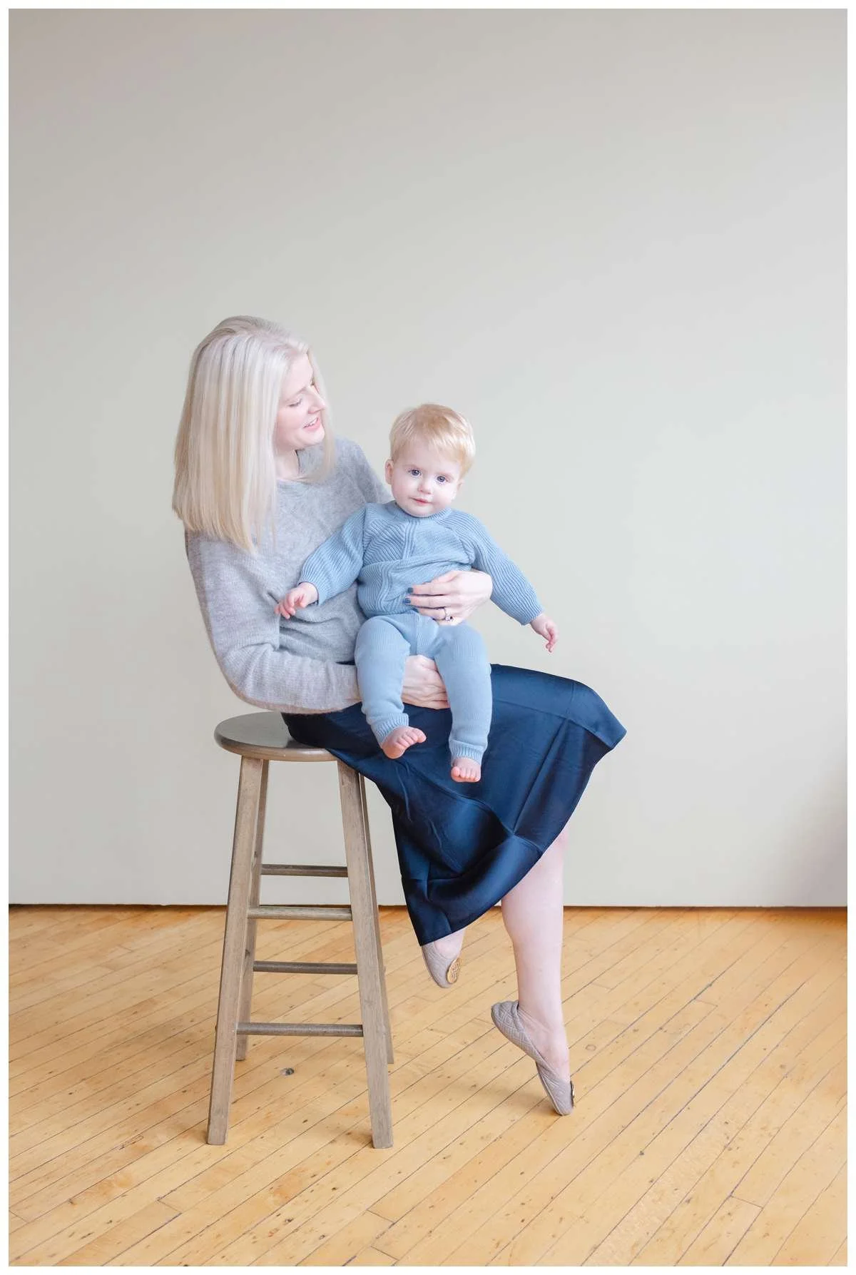 Chicago studio photography of a mom sitting on barstool and holding one year old son on lap