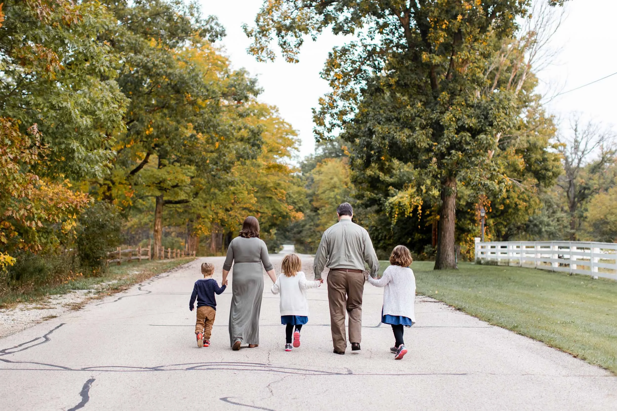 Family walking and holding hands during an outdoor family photography session 