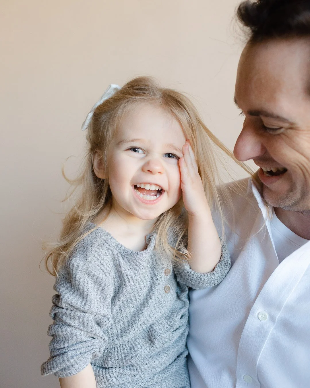 Studio portrait of Chicago girl with hand on face and cheeky smile