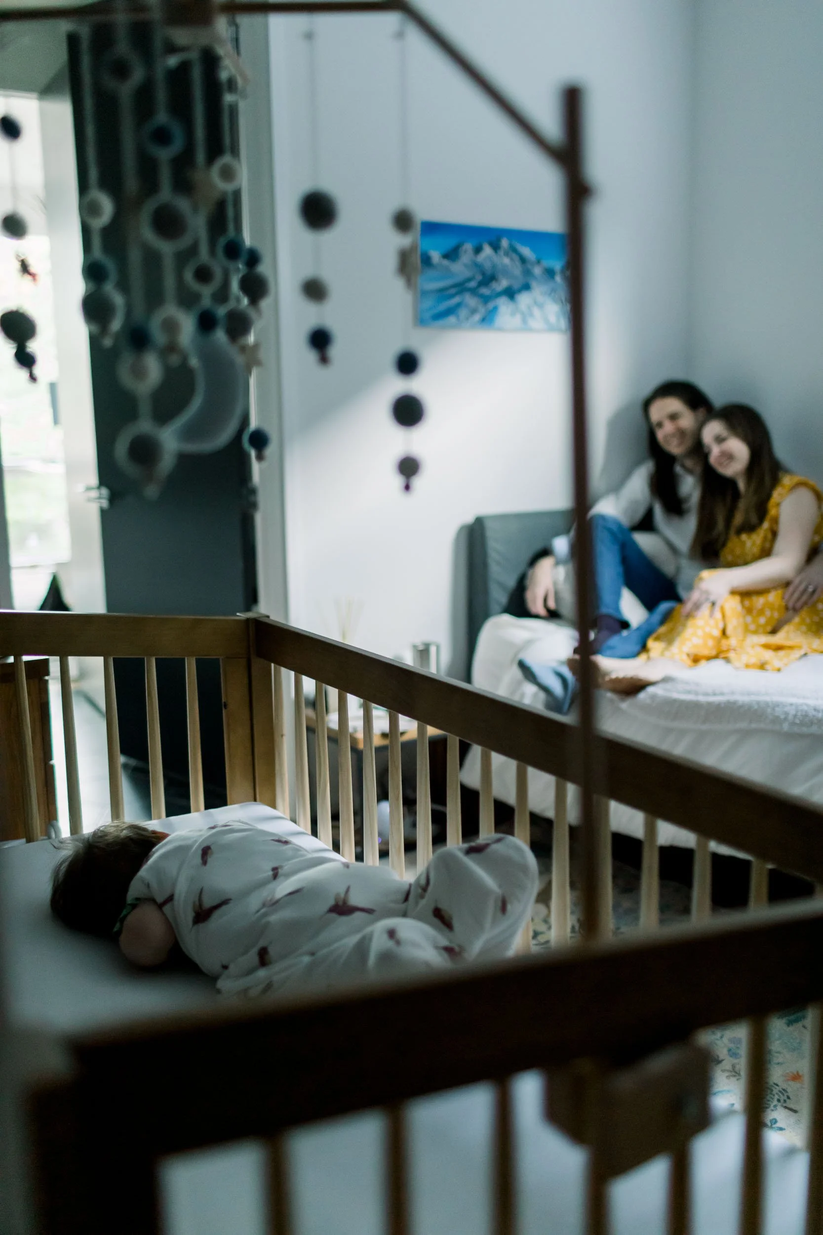 Lifestyle photography of Chicago parents watching baby sleep in crib