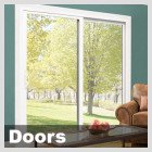Indoor view of a sliding glass door leading to a backyard with trees.