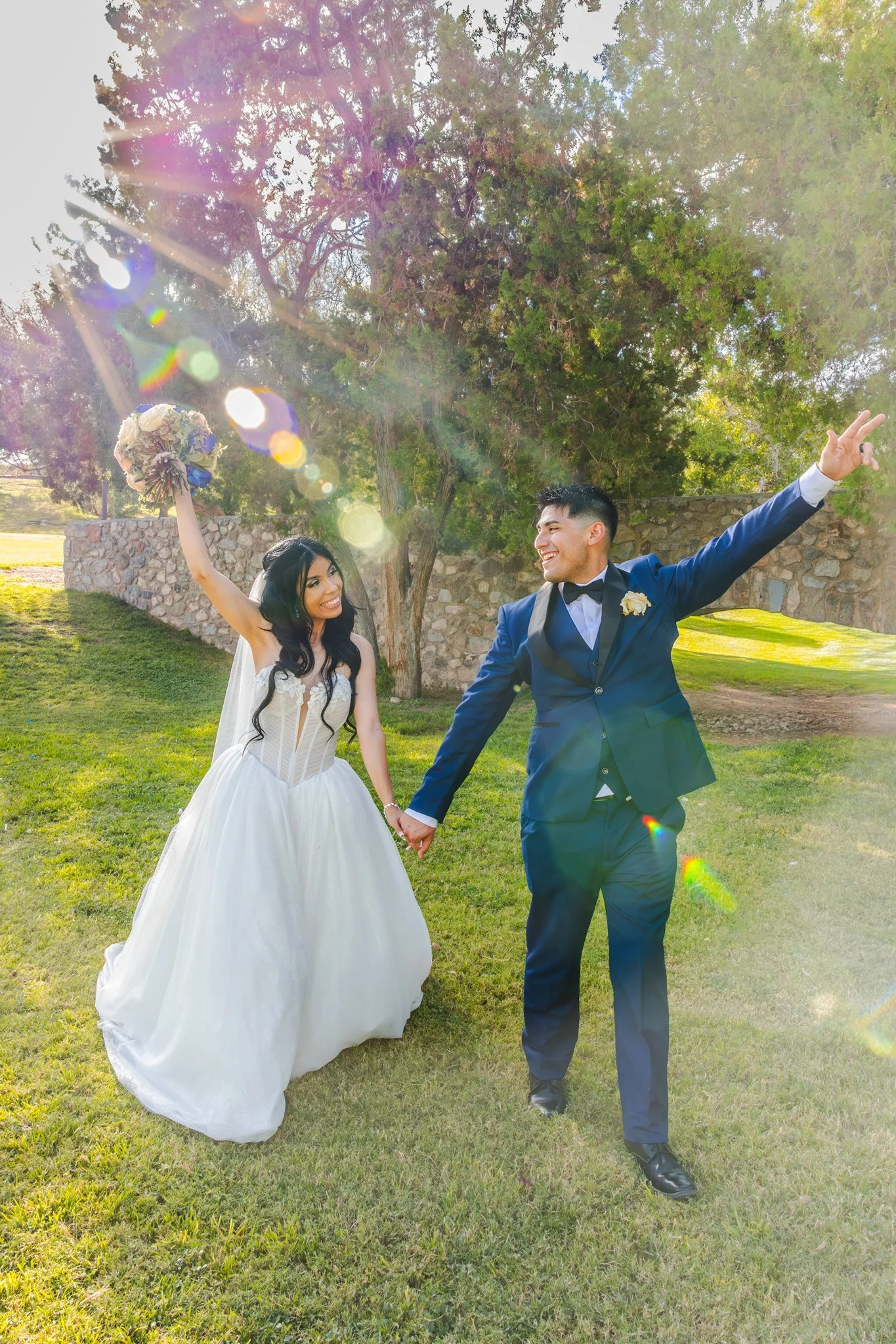 El Paso, Texas newlywed couple celebrating their wedding day and cheering at Memorial Park during golden hour.