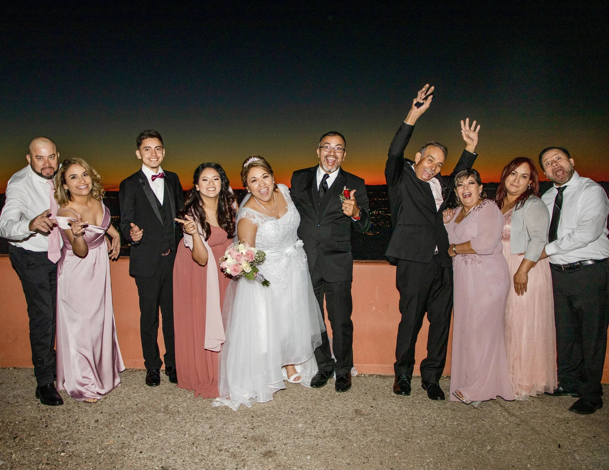 Group of people at a wedding celebration outdoors during sunset on Transmountain Road in El Paso, Texas.