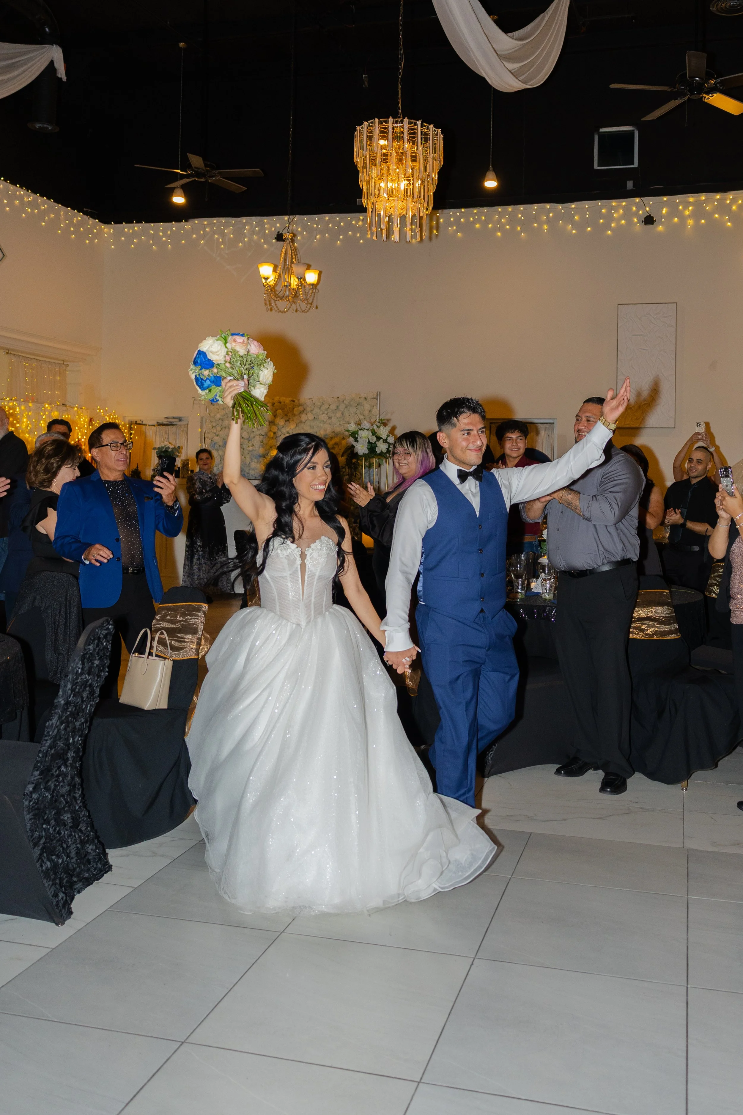 An El Paso bride and groom dancing at their wedding reception, with guests surrounding them and decorations including string lights and drapery overhead.