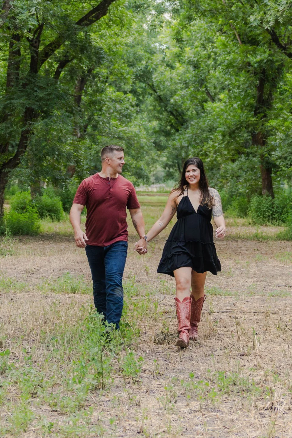 An El Paso couple walking hand in hand through the Mesilla Valley pecan trees in New Mexico, smiling and enjoying each other's company.