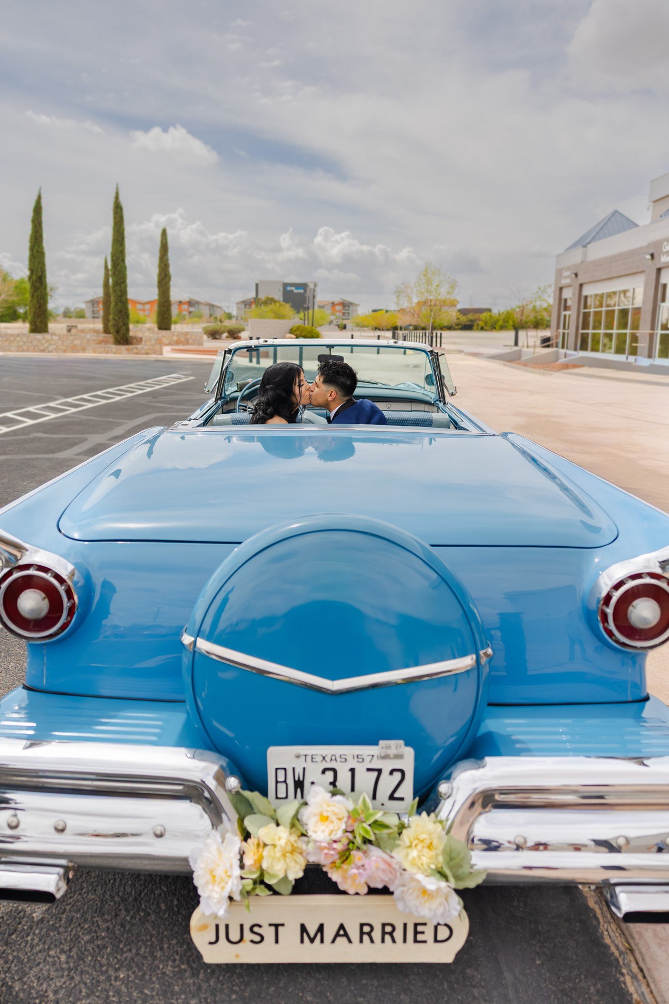El Paso, Texas newlywed couple kissing in a vintage car after their wedding ceremony at Christian Church.
