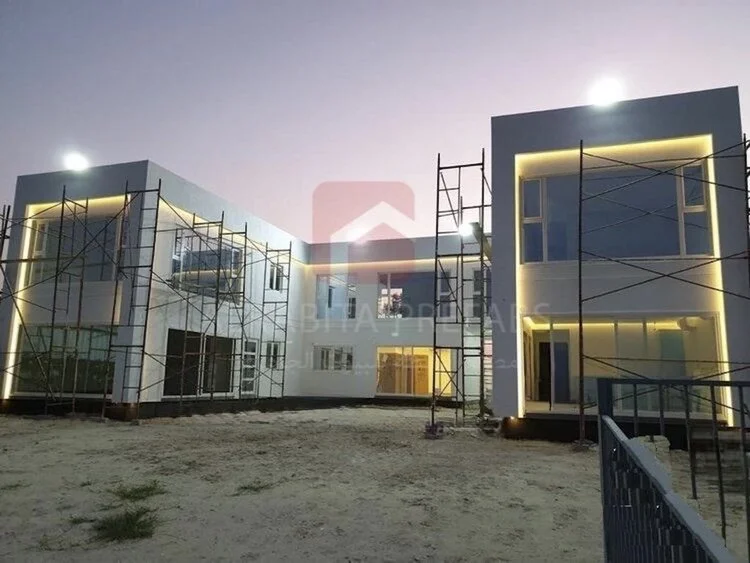 Under construction modern two-story prefabricated chalet with large glass windows executed by Alrabita Prefab Co. شاليه جاهز دورين بتصميم مودرن قيد الانشاء بشبابيك كبيرة واضاءة خارجية مميزة تم تنفيذه من قبل مصنع الرابطة للبيوت الجاهزة