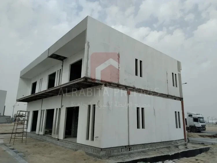 White prefabricated two-story building with multiple narrow windows executed by Alrabita Prefab Co. مبنى دورين جاهز مع شبابيك مميزة تم تنفيذه من  قبل مصنع الرابطة للبيوت الجاهزة