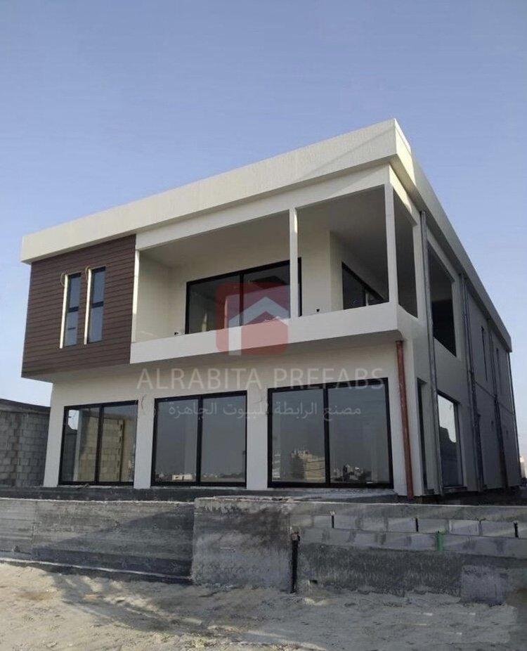 A modern two-story prefabricated house with large glass windows executed by Alrabita Prefab Co. بيت جاهز دورين بتصميم مودرن وشبابيك كبيرة تم تنفيذه من قبل مصنع الرابطة للبيوت الجاهزة
