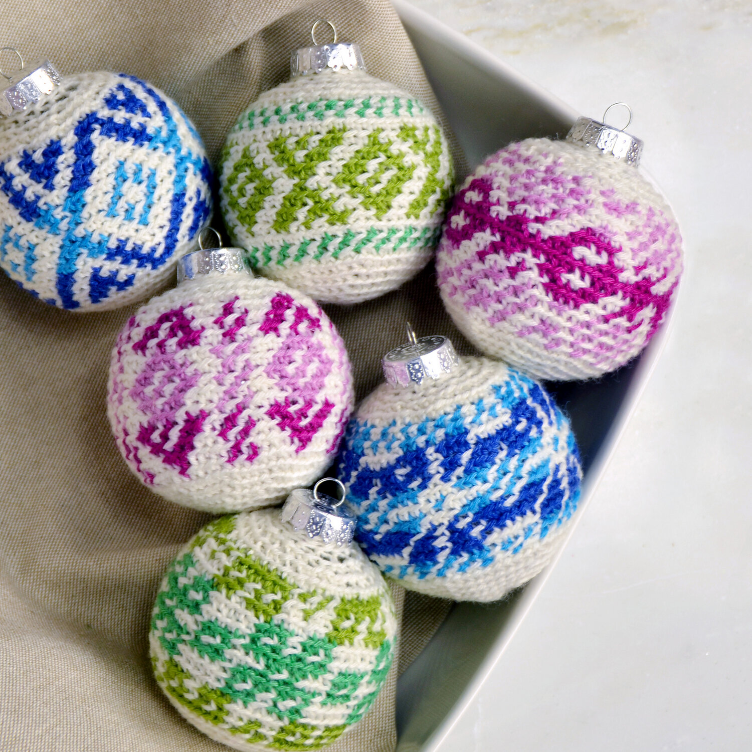 crochet pattern work ornaments in pink, blue, and green