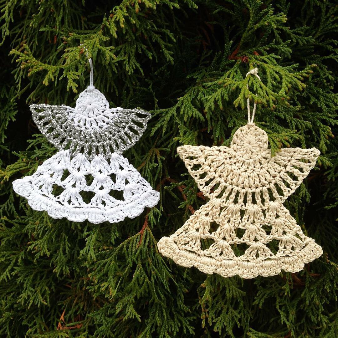 two handmade crochet angel ornaments hanging on a tree
