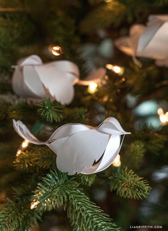 white paper bird ornaments on a tree