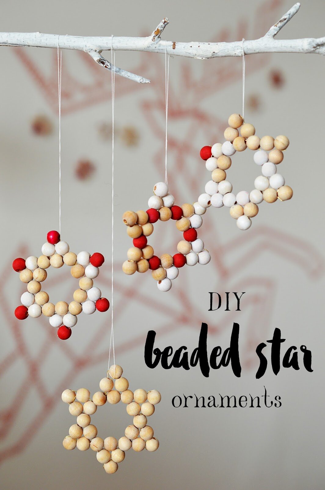 handmade star ornaments made with light wood, white, and red beads