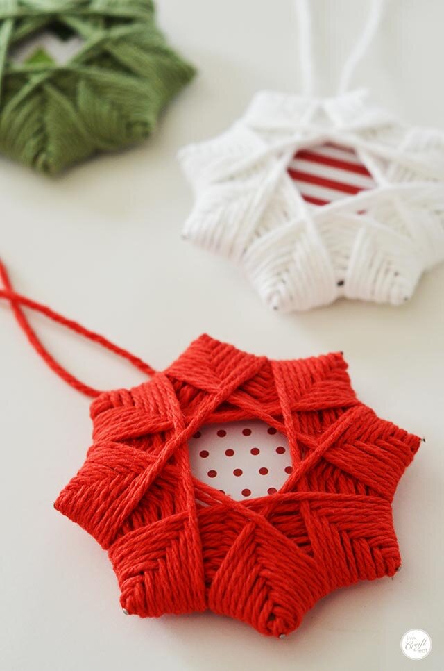 eight pointed handmade star ornaments made with paper and yarn