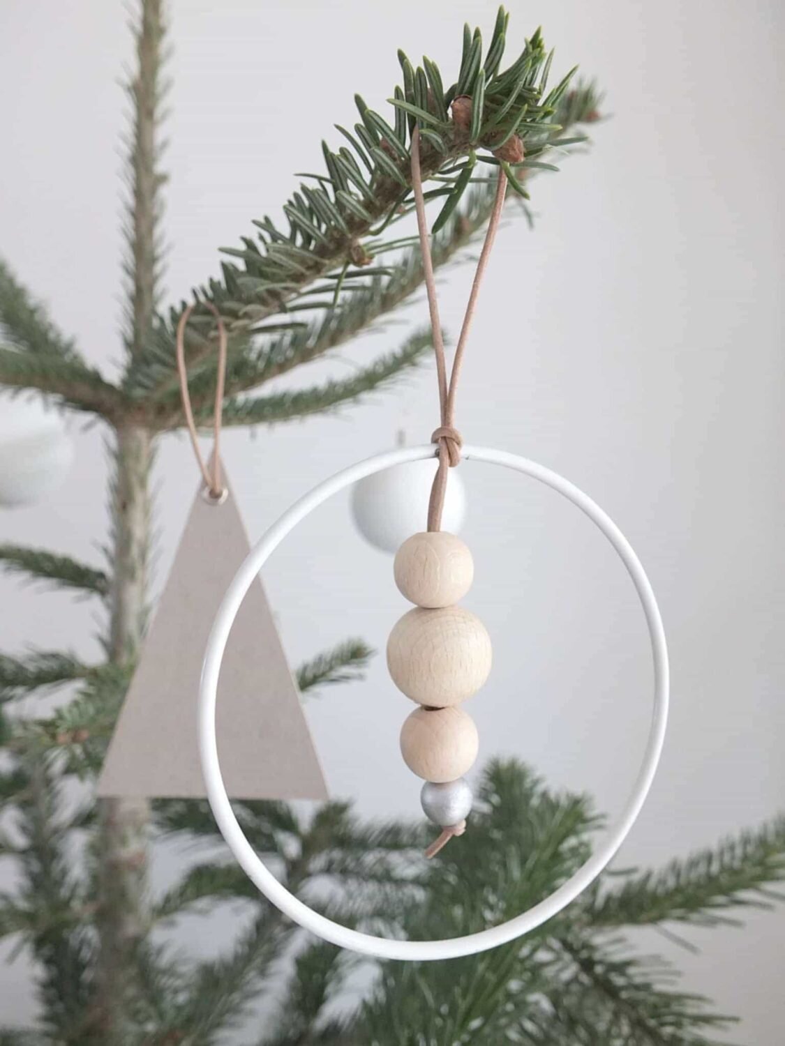 ornament with a white hoop, light wood beads, and a silver bead