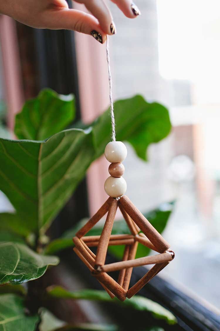 homemade geometric ornament made from wooden beads and cinnamon sticks