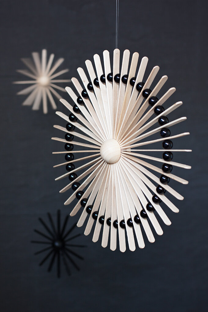 moden sunburst ornament made from popsicle sticks and black beads